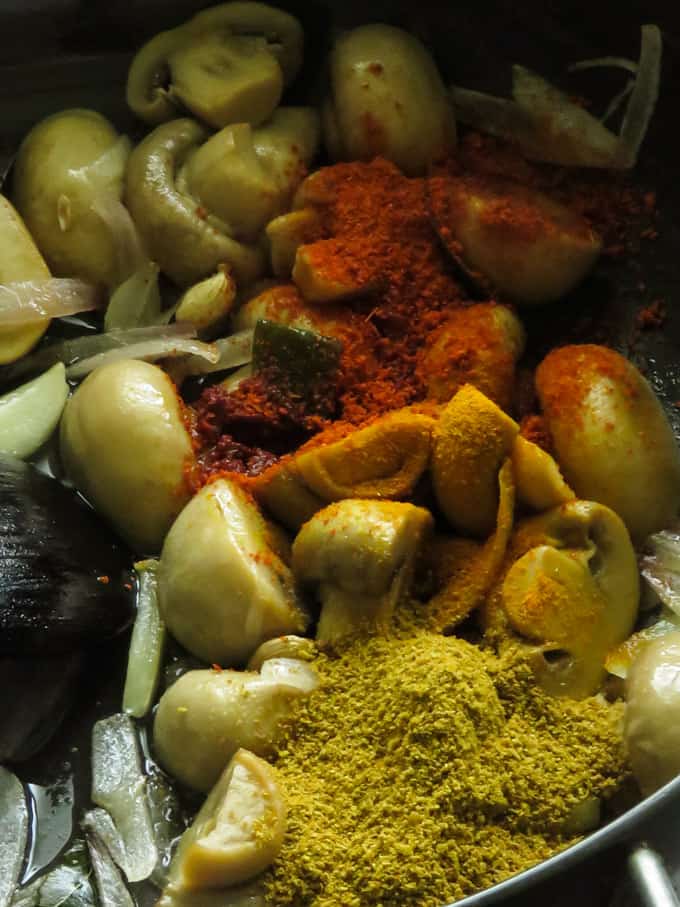 adding spices for the mushroom curry.