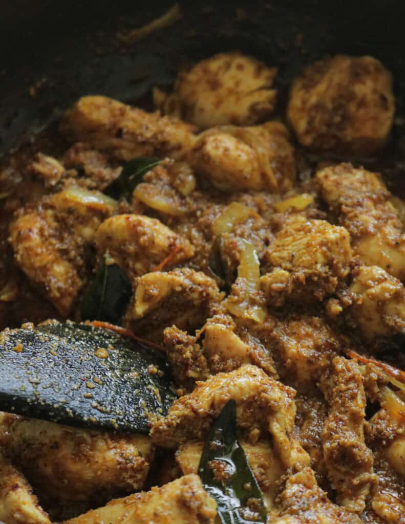 cooking the chicken with the chettinad masala to cook the chettinad curry.