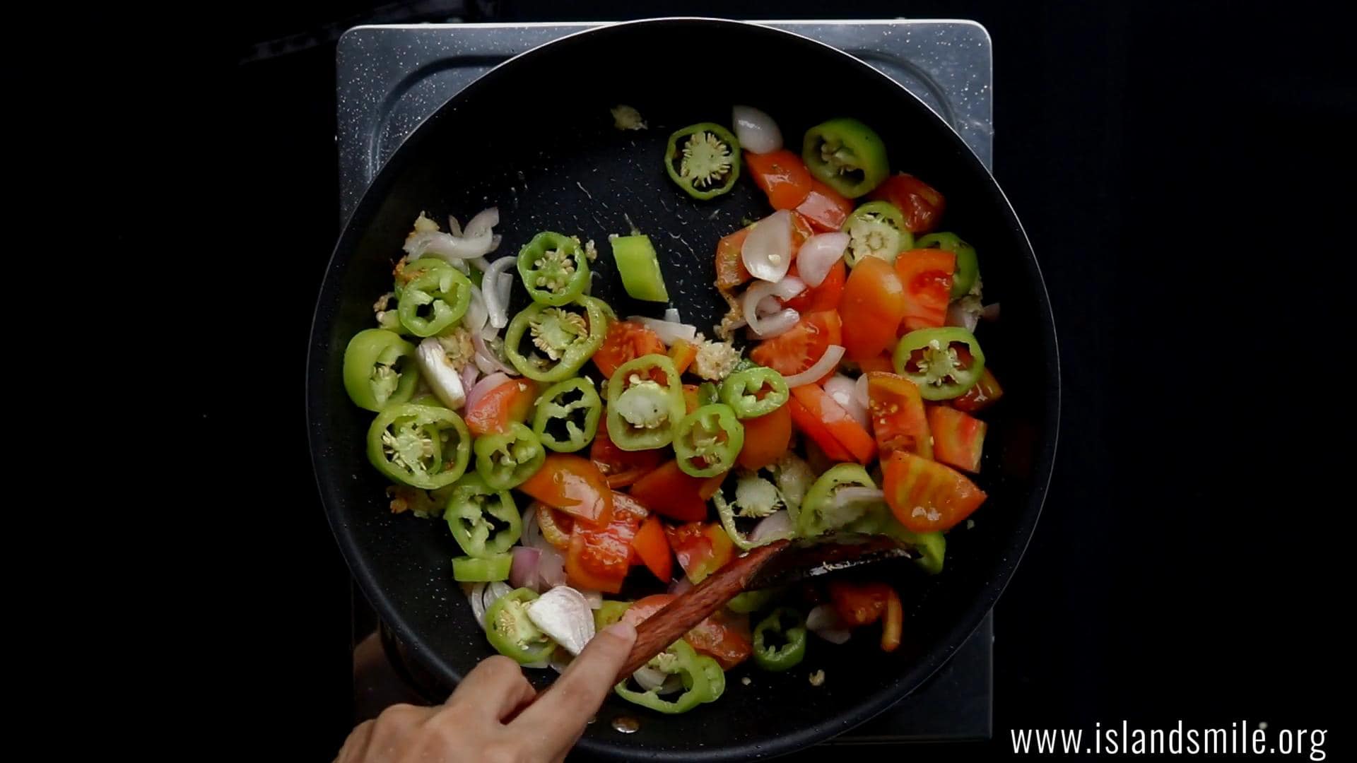 cooking the banana pepper, onions and the chopped tomatoes.