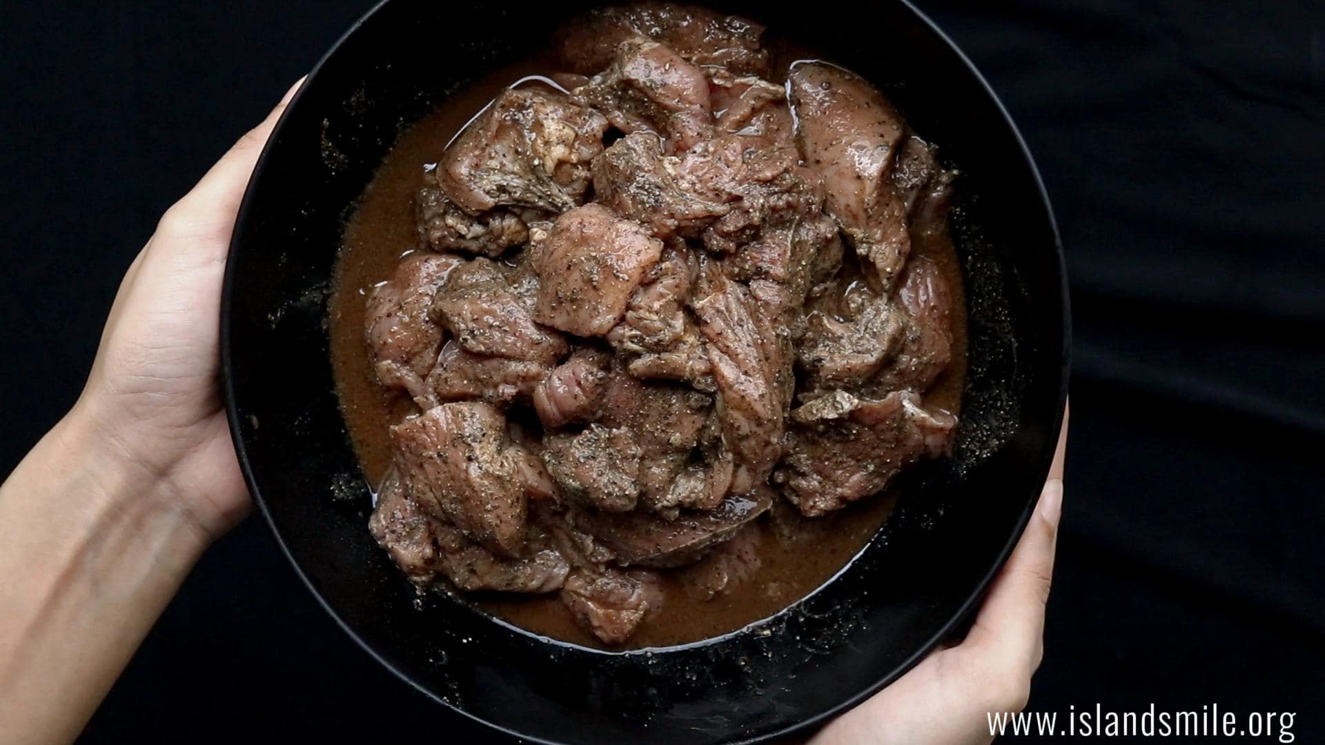Marinating the beef with vinegar and soy sauce.