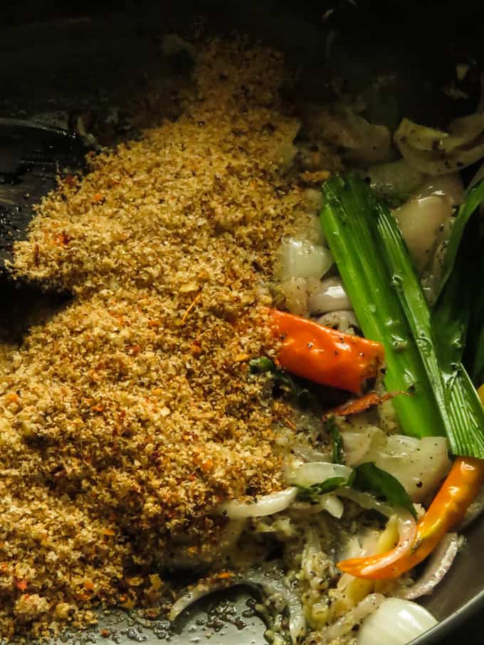 cooking the ingredients in the pan to make the chicken curry.