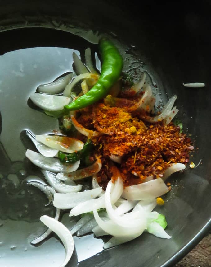 tempering onions, chillie powder, green chillie, turmeric to make the banana flower curry.