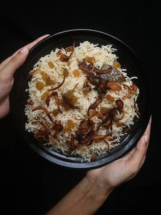 ghee rice with fried onions garnished over the rice.