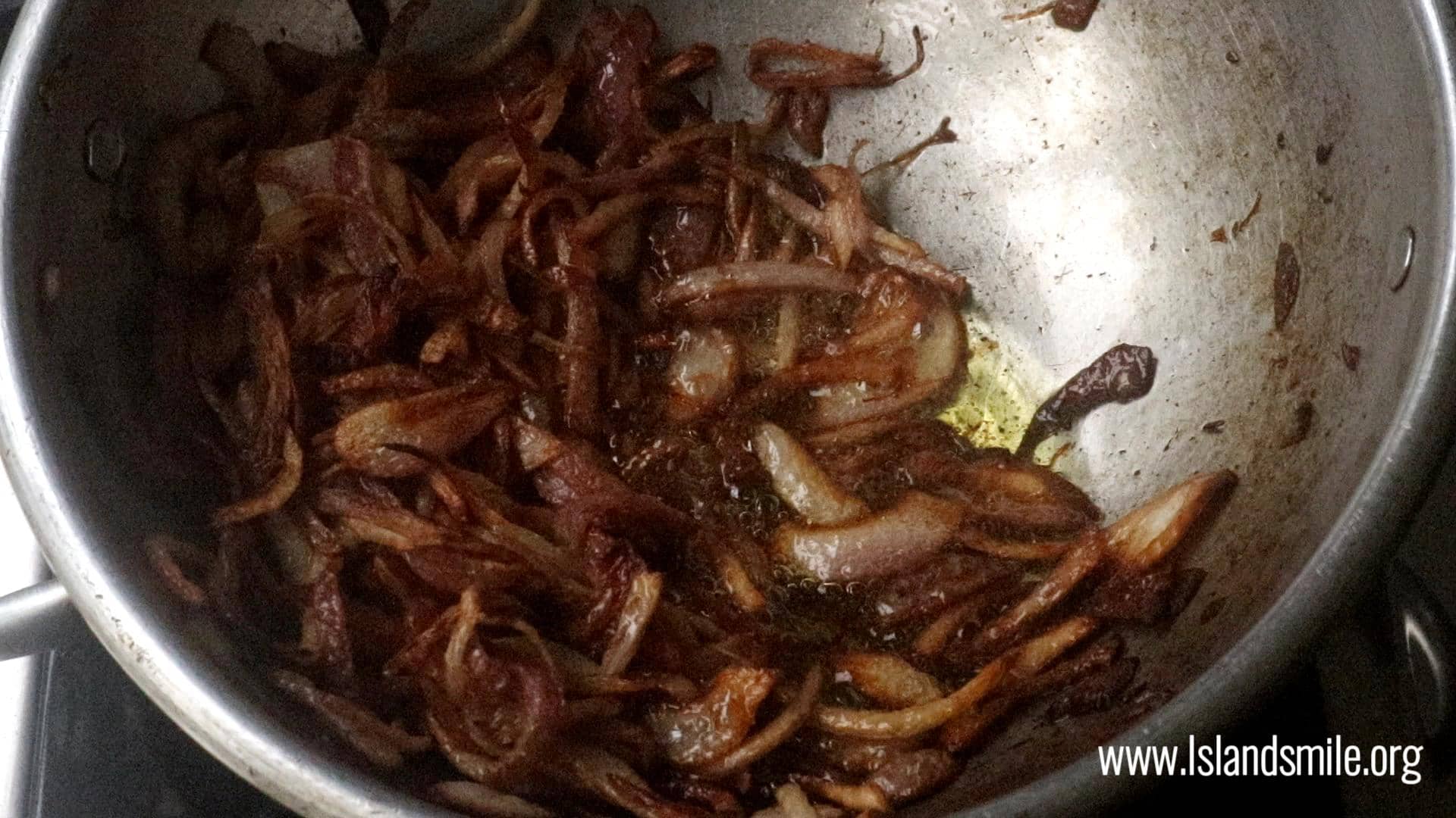 frying the sliced onions to garnish the ghee rice.
