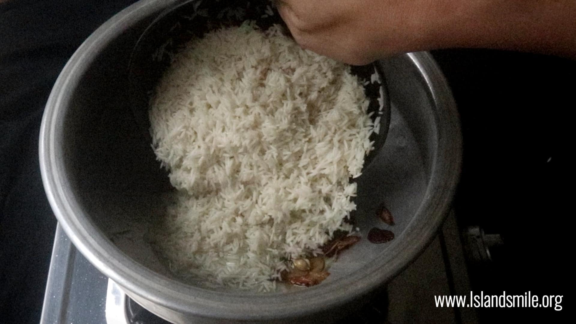 adding the soaked rice the fragrant aromatics to cook the ghee rice.