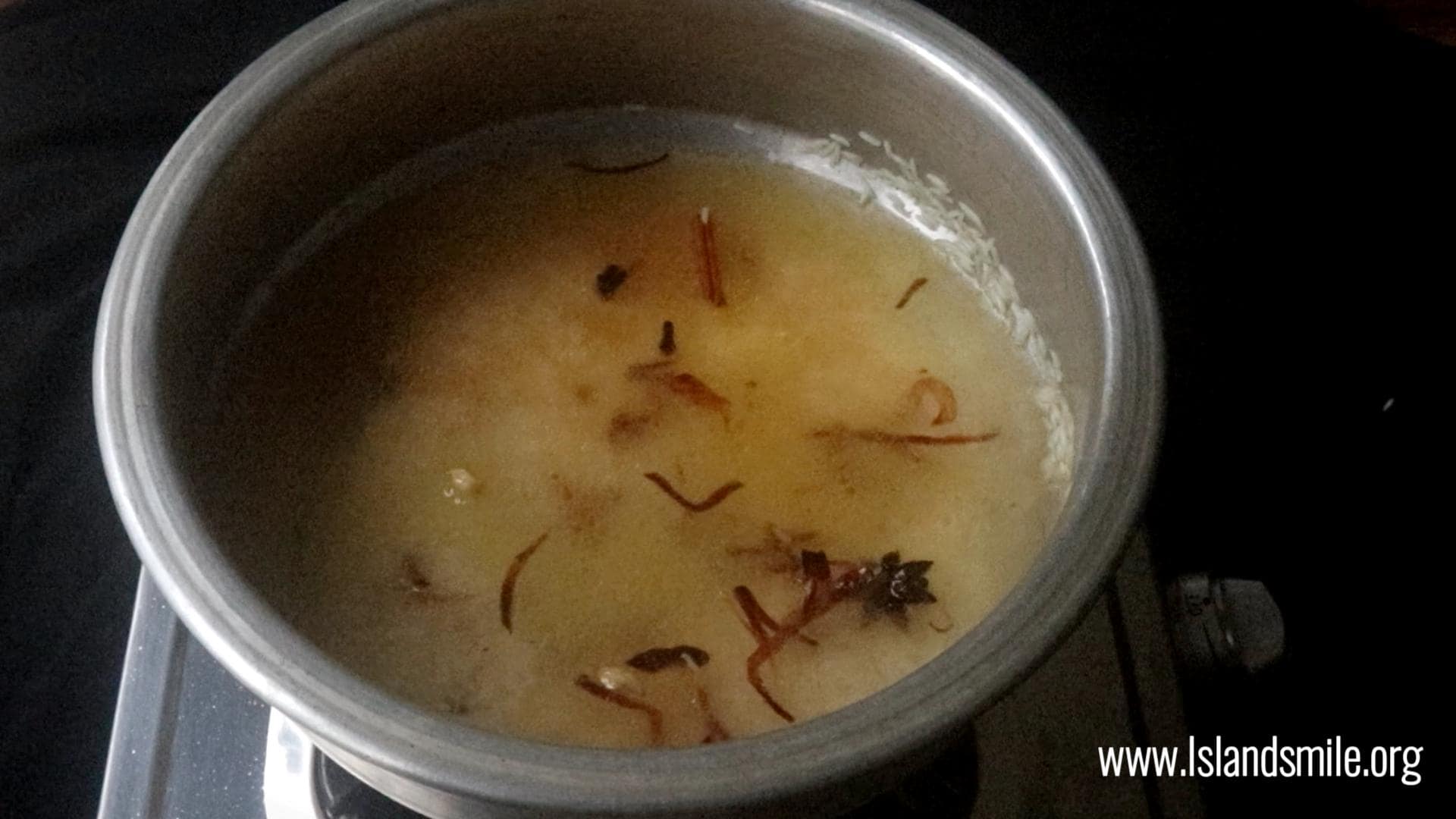 adding the water to rice to cook the ghee rice.