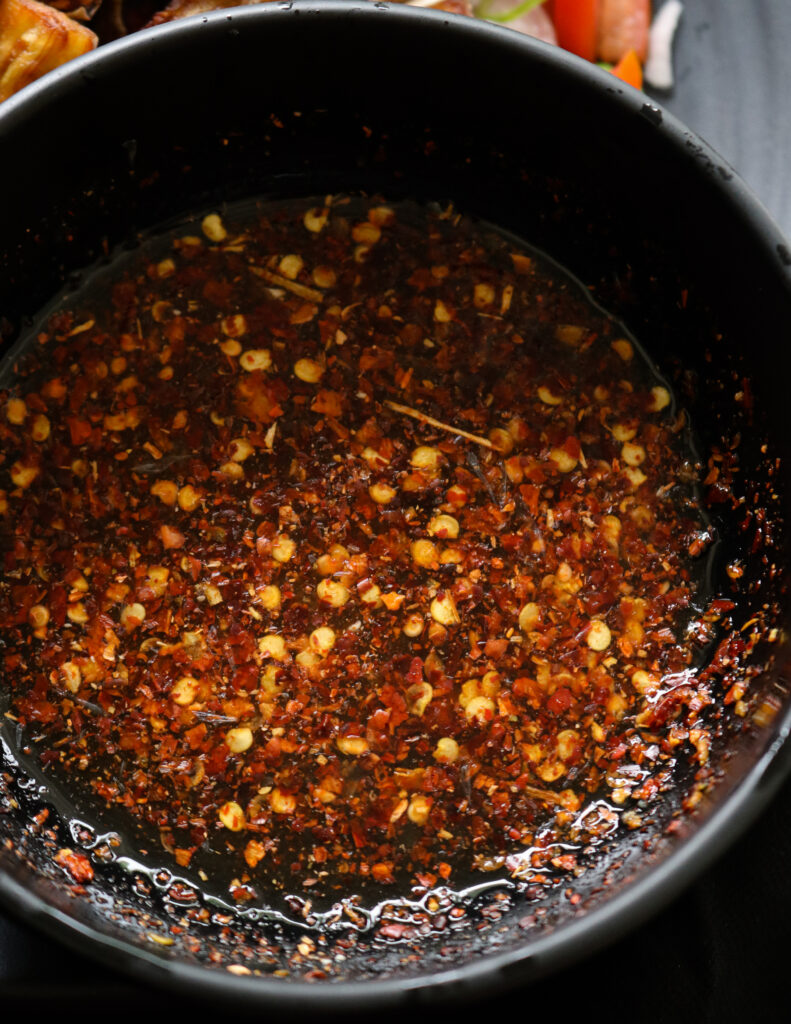  ixing vinegar and red chilli flakes and sugar in a bowl