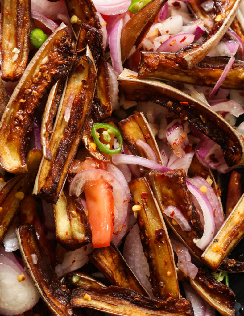 fried eggplants/brinjals mixed with sliced onions and tomatoes