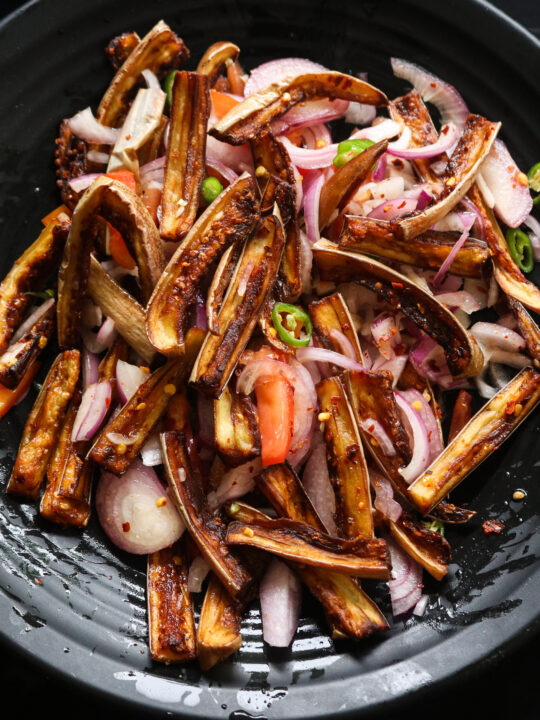 Sri lankan brinjal salad served in a black plate.