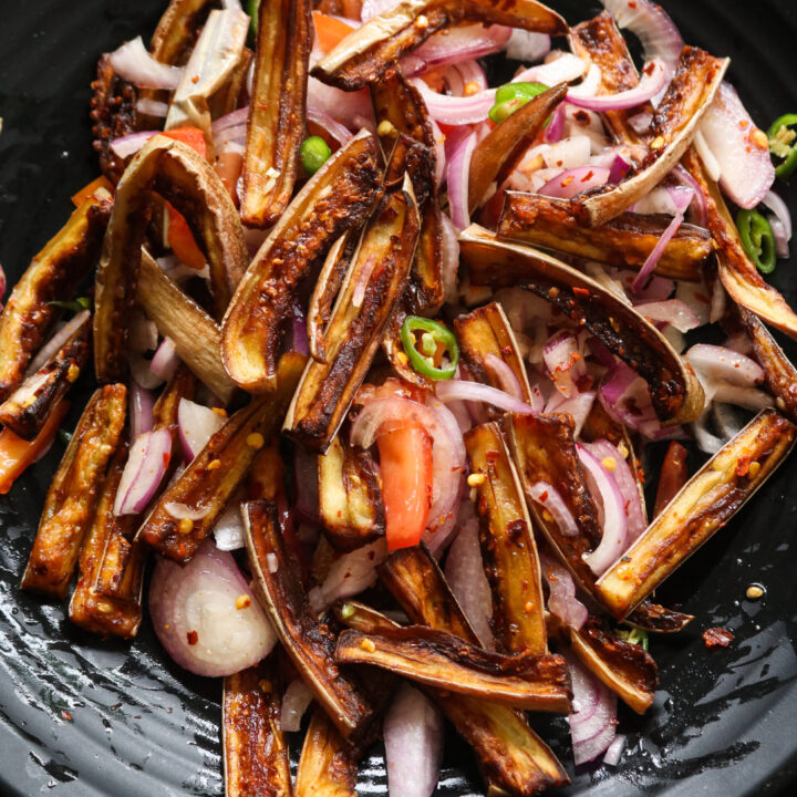 Sri lankan brinjal salad served in a black plate.