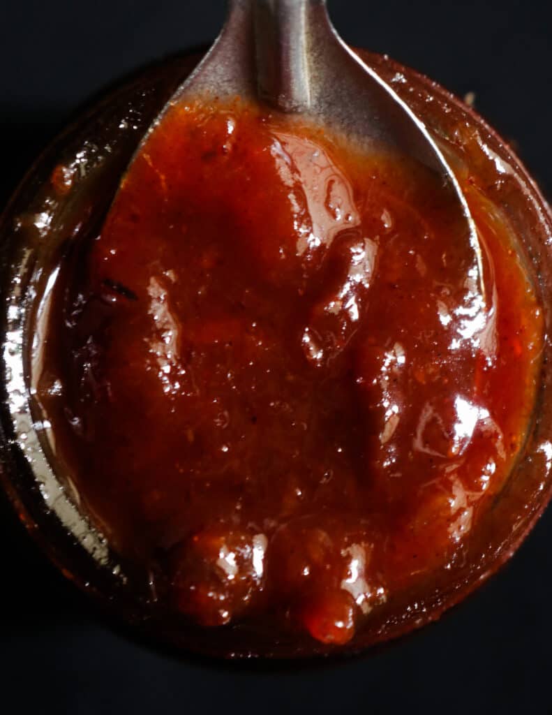 thick date and lime chutney scooping with a silver spoon.