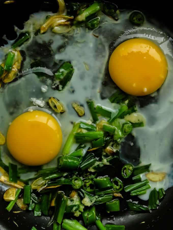 garlic, spring onions and egg in wok.