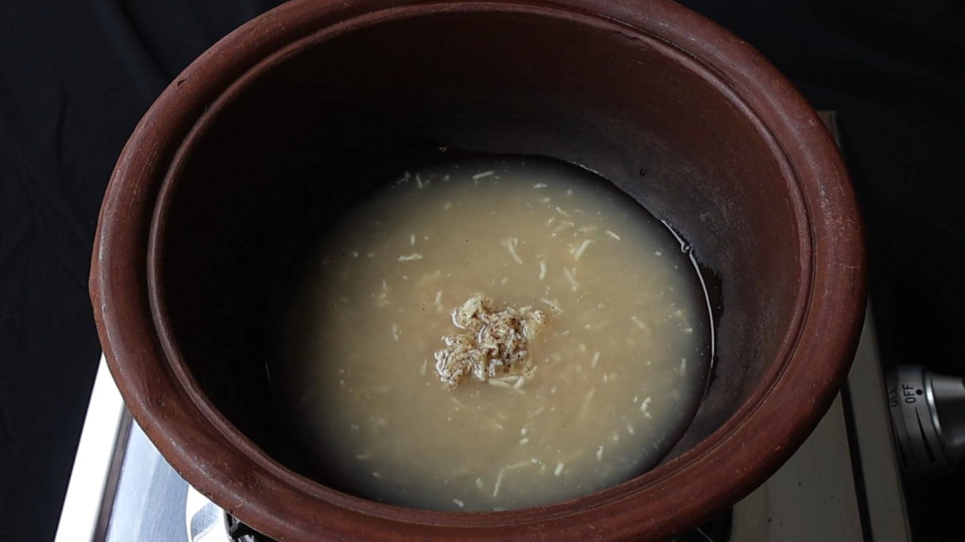 pour in vinegar to the clay pot with the mustard paste to make date and lime chutney.