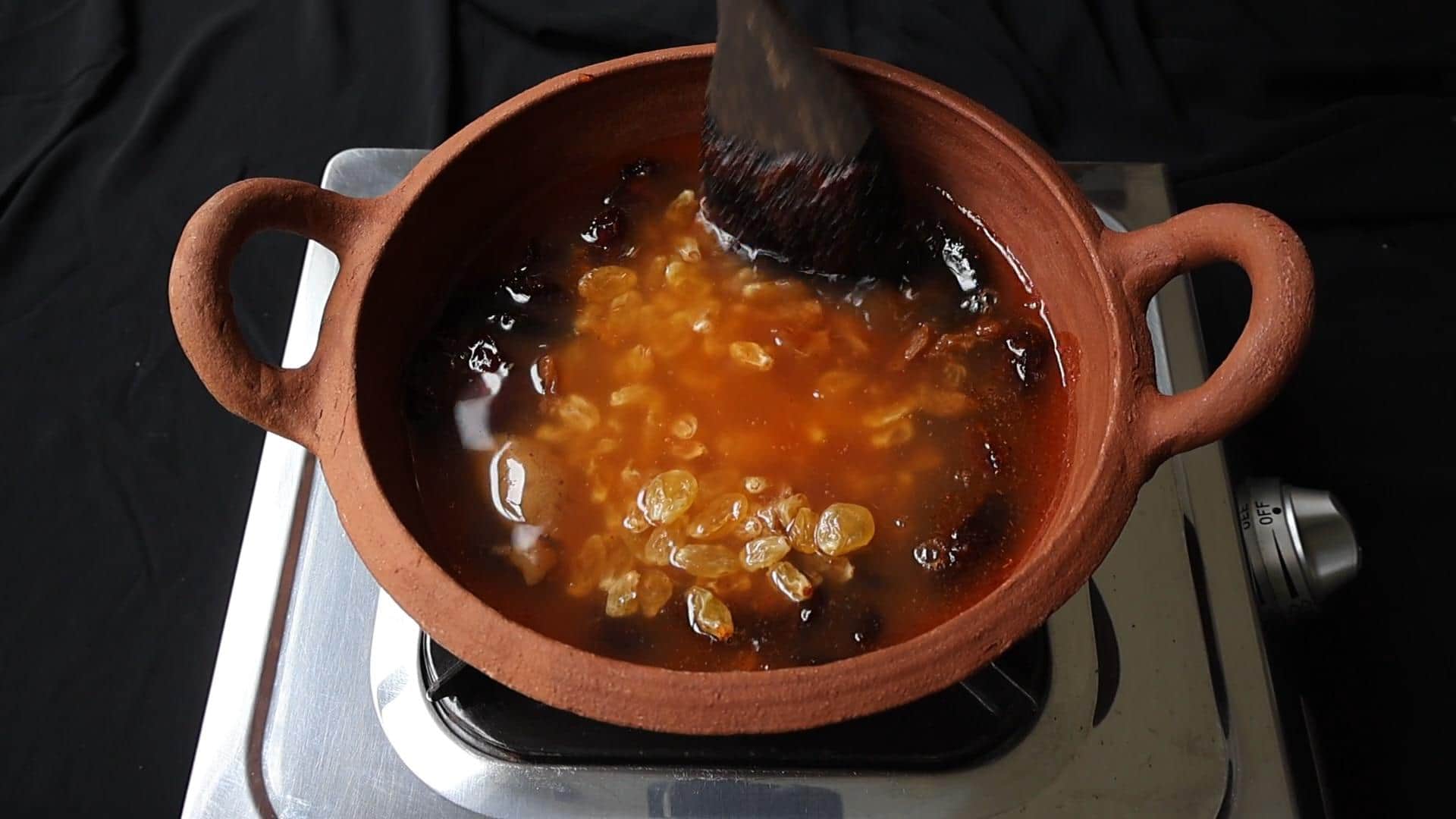 cooking the date, lime and raisins in the vinegar mixture.