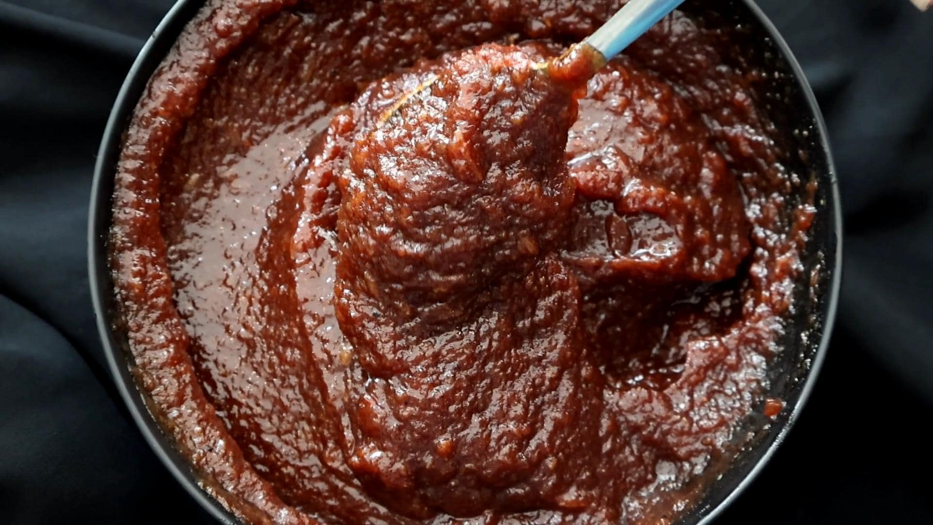 date and lime chutney served in a bowl with a silver spoon.