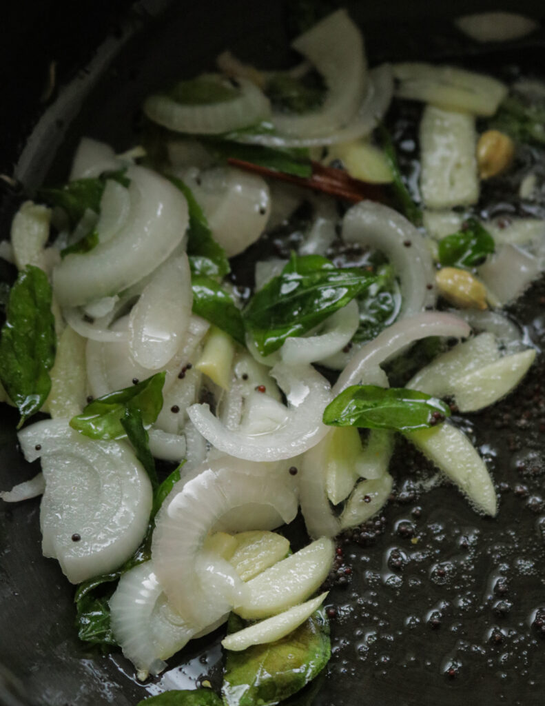 frying onions, garlic, curry leaves, mustard seeds in oil.