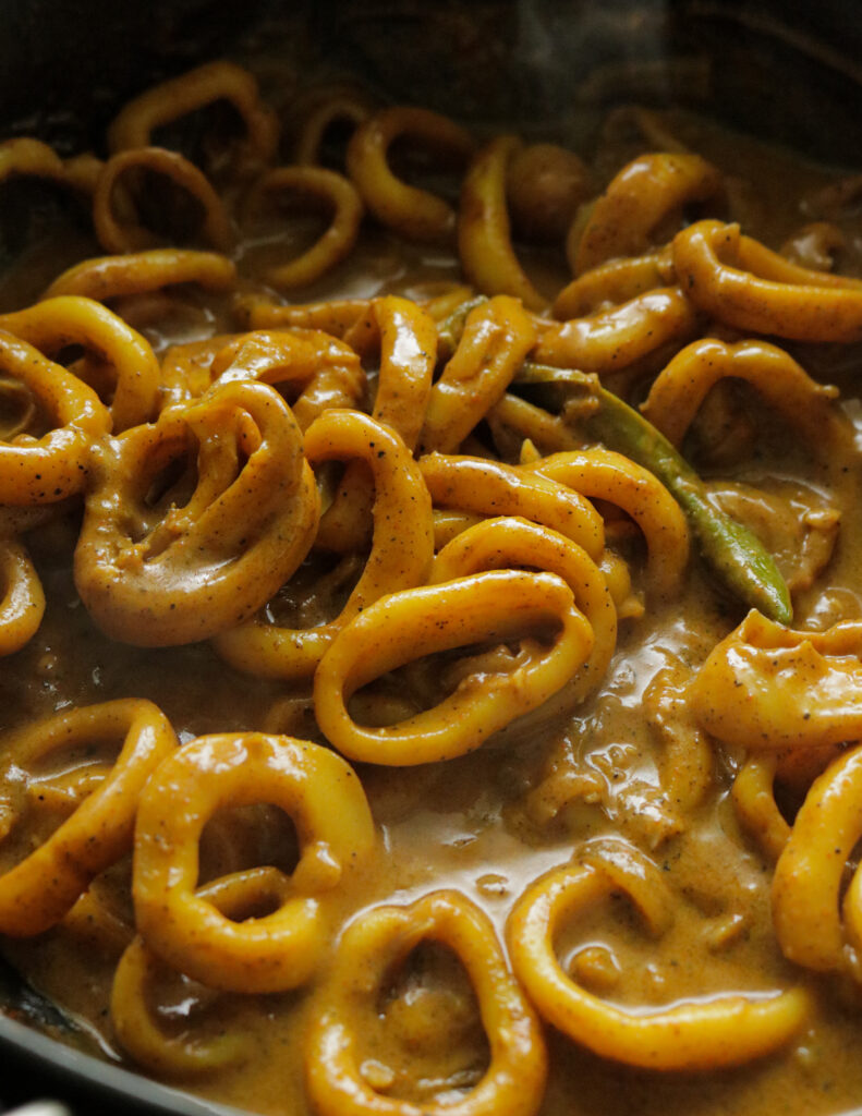 calamari curry with pepper and coconut milk cooked in a clay pot.