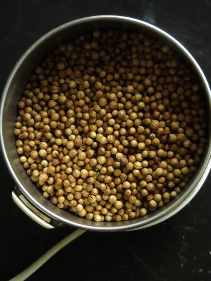 coriander seeds placed in a grinder to turn into a spice powder.