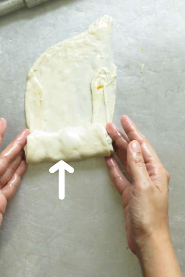 continue rolling the dough over the filling for the vegetable roti.