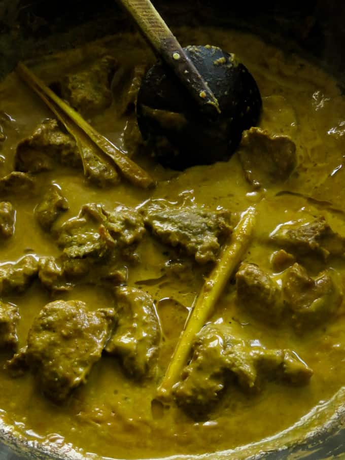 slow cooking the beef curry in lemon grass-coconut milk gravy.