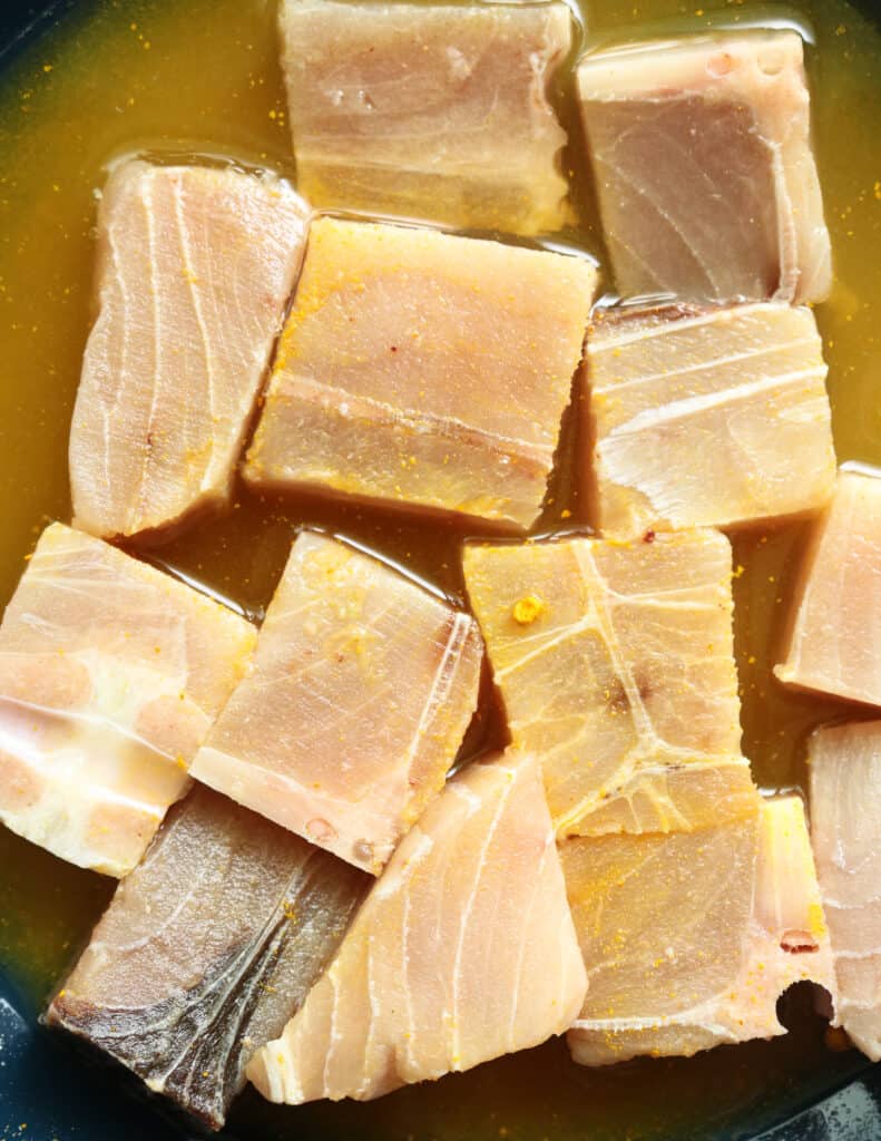 rinsing the sailfish chunks with turmeric and water