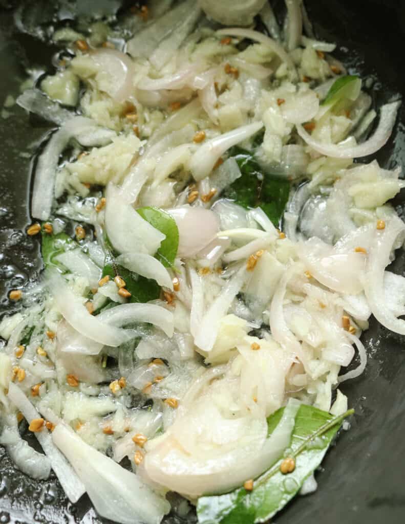 frying onions,garlic, curry leaves to make the fish curry