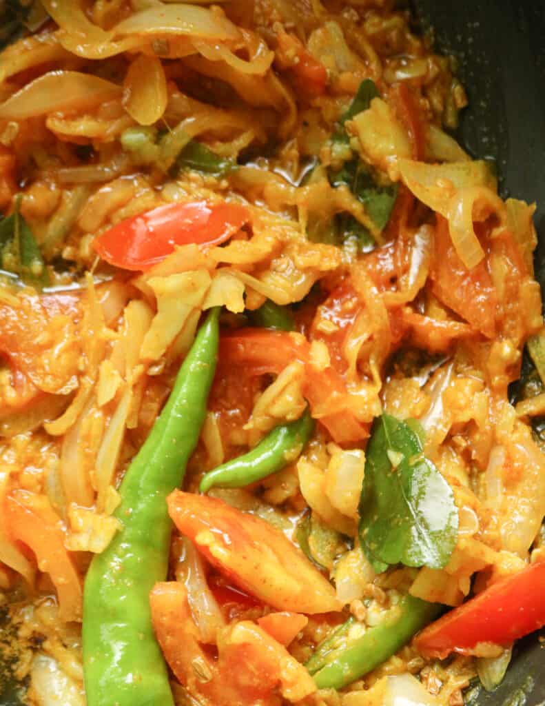 cooked onions. curry leaves, tomato in oil to make the creamy fish curry