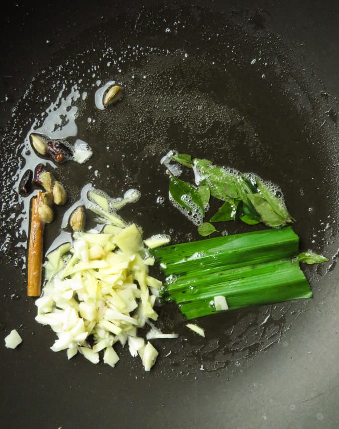 tempering the aromatic spices for the vinegar chicken.