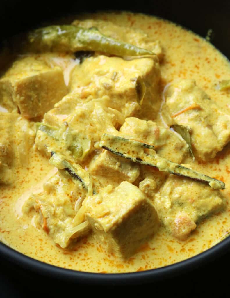 cremay coconut milk fish curry served in a black bowl