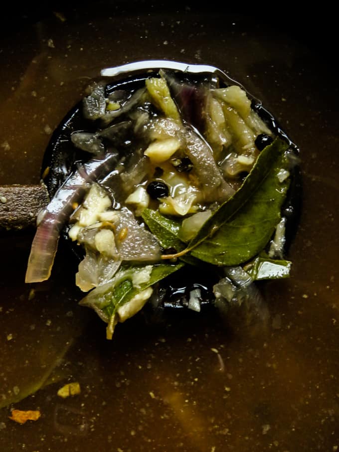 tamarind soup ingredients in a spoon.