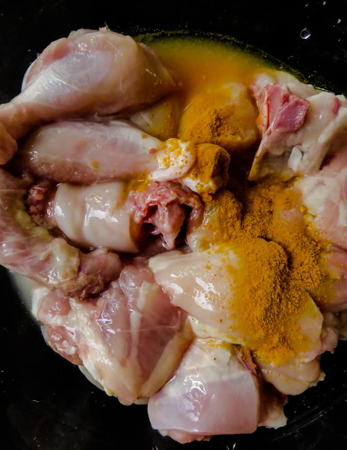 washing the chicken in turmeric.