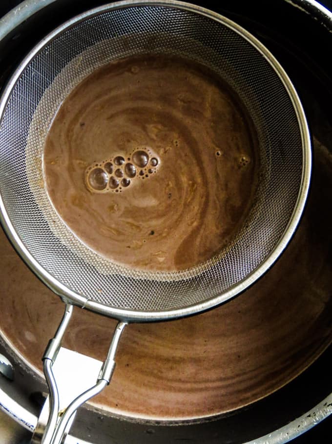 straining the chocolate pudding mixture.