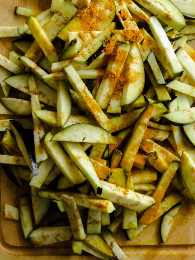 eggplant strips in turmeric for pickled brinjal moju.