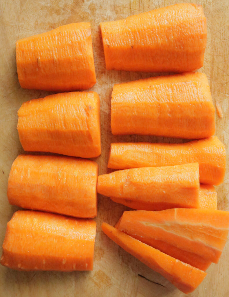 cutting the carrot in two and halved to slice the carrot.