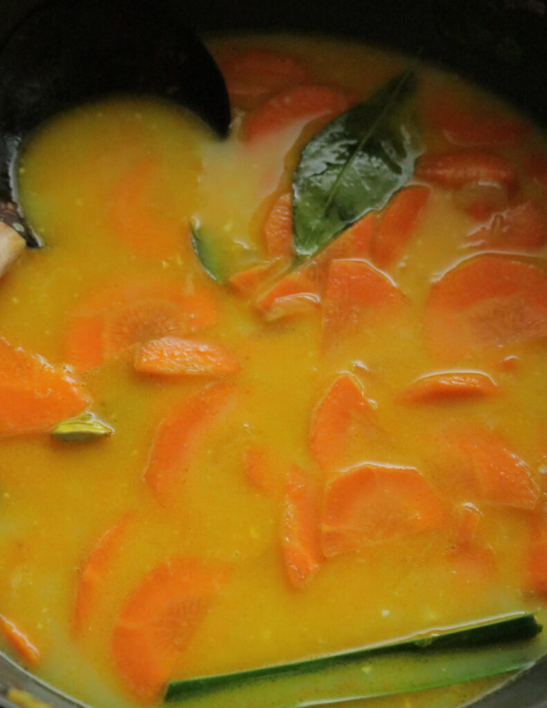 adding thin coconut milk to make the carrot curry.