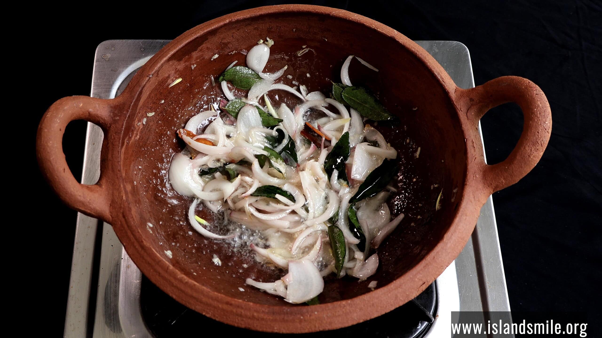 tempering curry leaves and onions to make the Sri Lankan white fish curry.