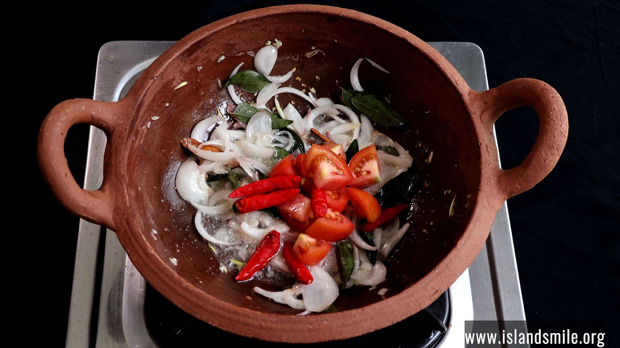adding chopped tomatoes and fresh chillies to make the sri lankan white fish curry.