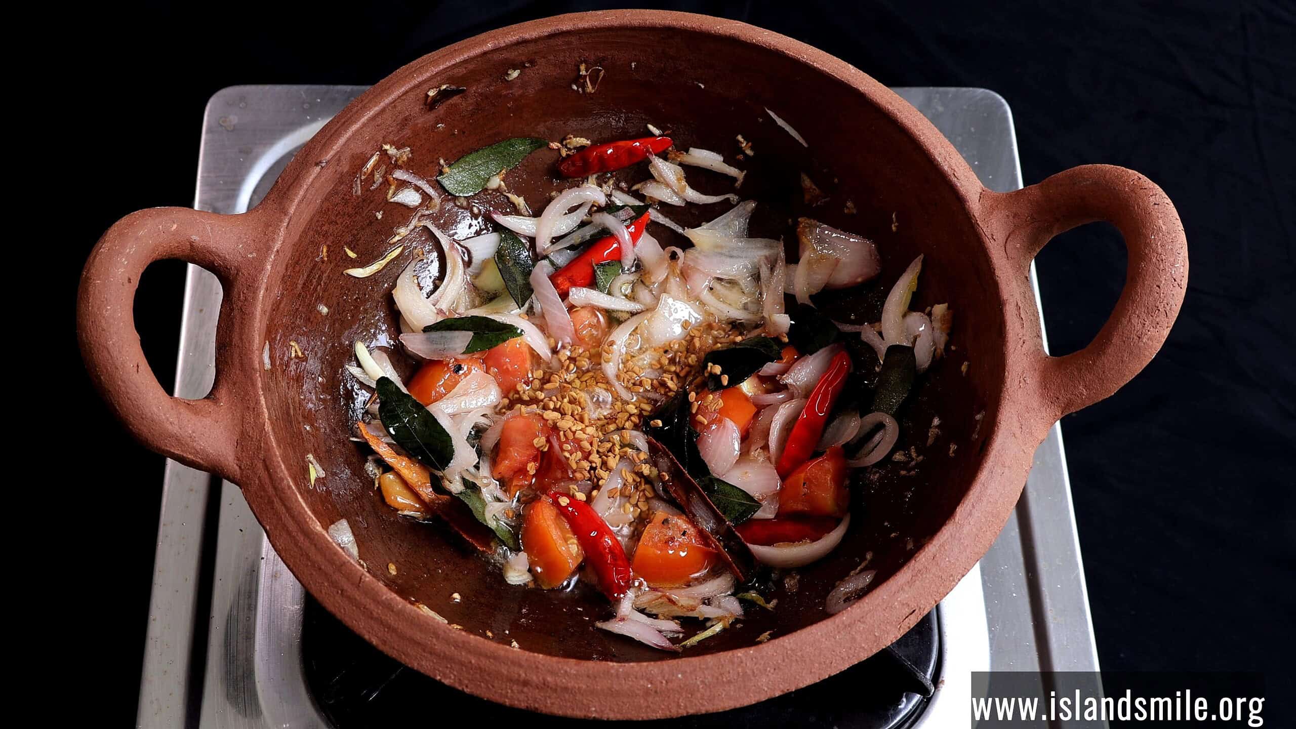 adding fenugreek to make the white fish curry.