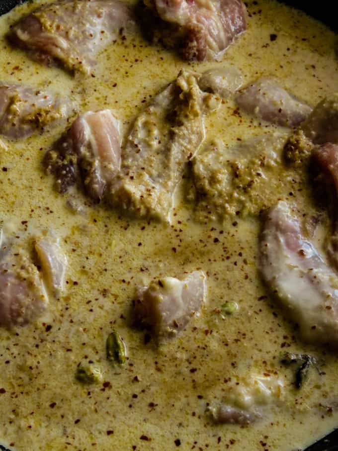 adding the chicken parts and coconut milk to make the chicken rendang.