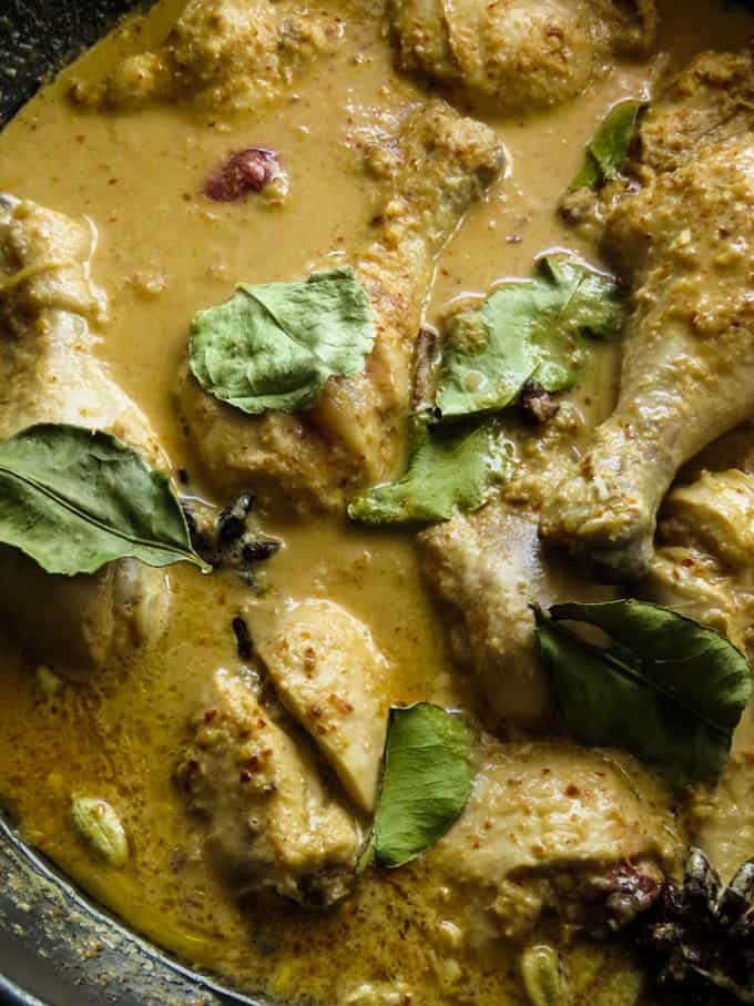 slow simmering the rendang chicken and adding the kaffir leaves to make the Malaysian curry.