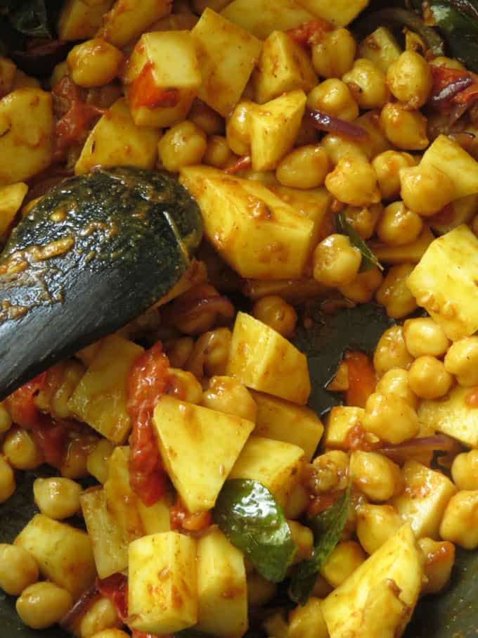 cooking potatoes and chickpeas in masala paste.