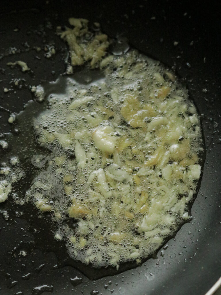 cooking the minced garlic and ginger in oil