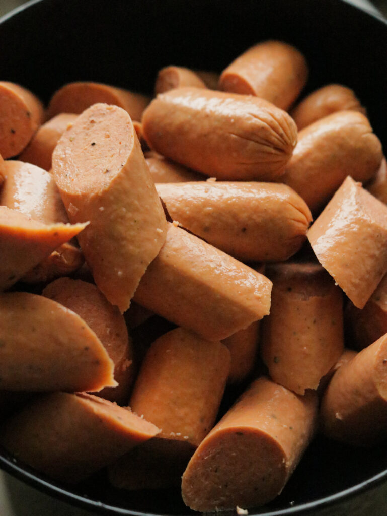 slicing the boiled sausages to make the devilled sausage recipe