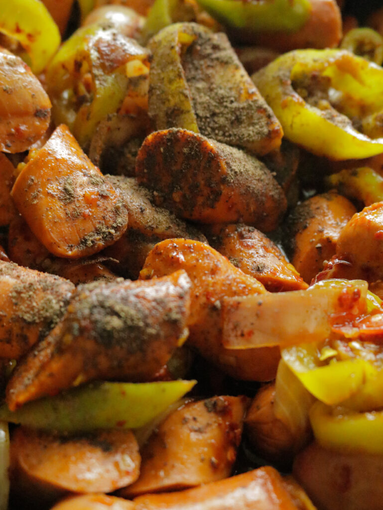 adding pepper powder to the cooking sliced sausages to make the devilled sausage recipe