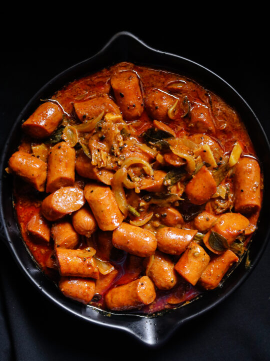 sausage curry served in a bowl.