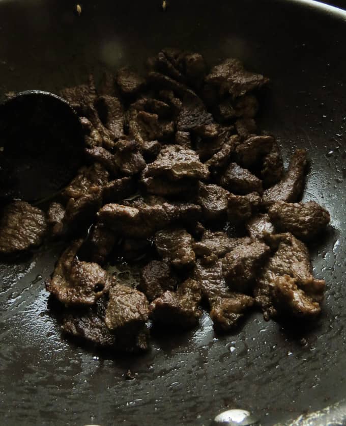 stir-fried beef slices in a wok.