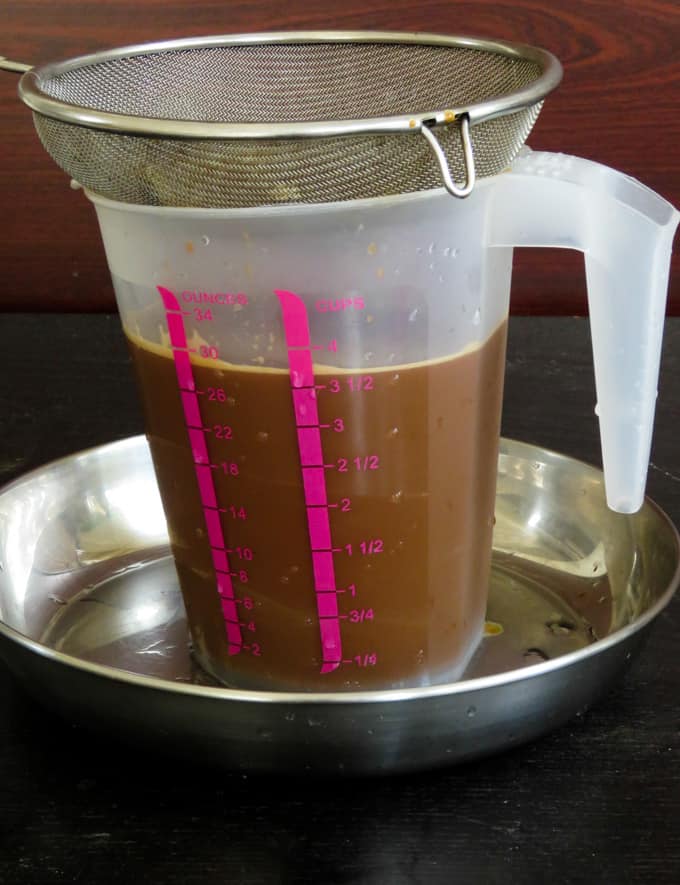 straining the Jaggery-coconut milk- egg mixture.