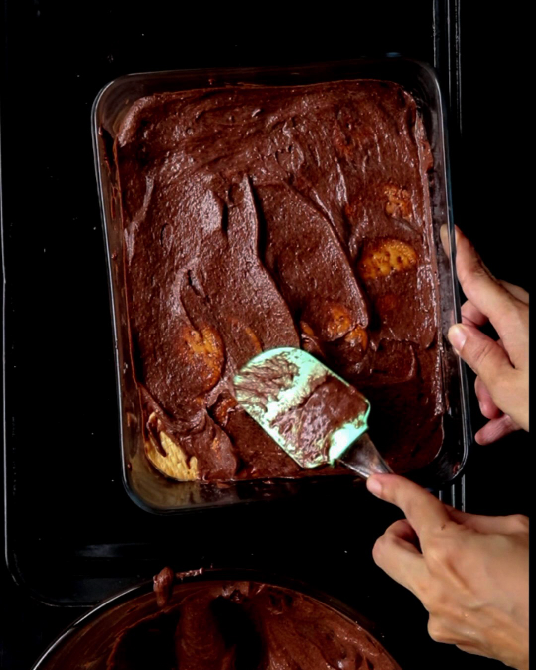 layering the last chocolate icing for the biscuit pudding.