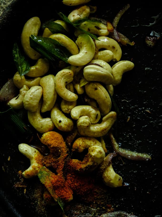 slightly toasting the cashew and adding the Sri Lankan spices to the pan.