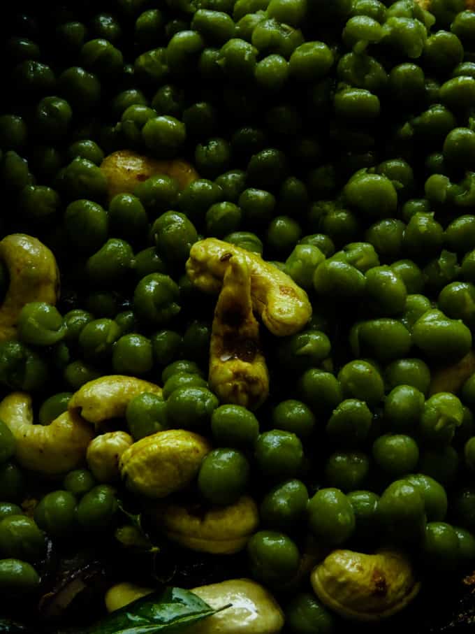 adding the green peas to the cashew curry.